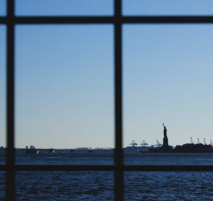 Fotografía artística conceptual Estatua de la Libertad Nueva York, vista a través de rejas, "Land of FREEDOM", silueta distante