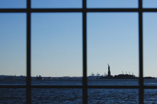 Fotografía artística conceptual Estatua de la Libertad Nueva York, vista a través de rejas, "Land of FREEDOM", silueta distante